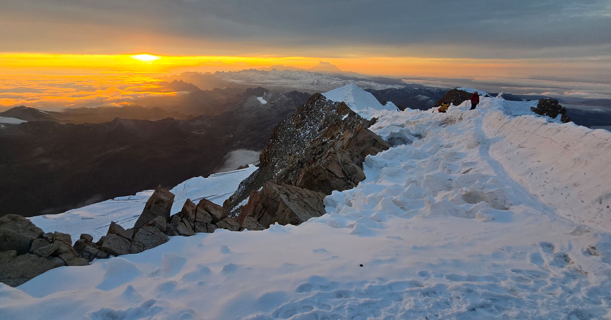 Climbers heading up as the sun begins to rise over the mountains.