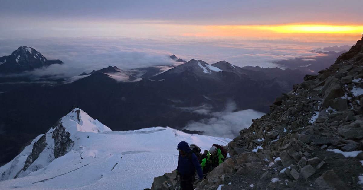 A view of the dark, serene peaks under the moonlight, moments before sunrise.