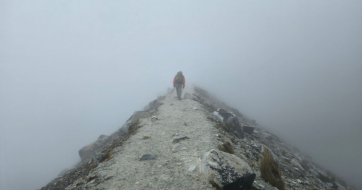 A stone hut surrounded by fog and snowfall on Huayna Potosí.