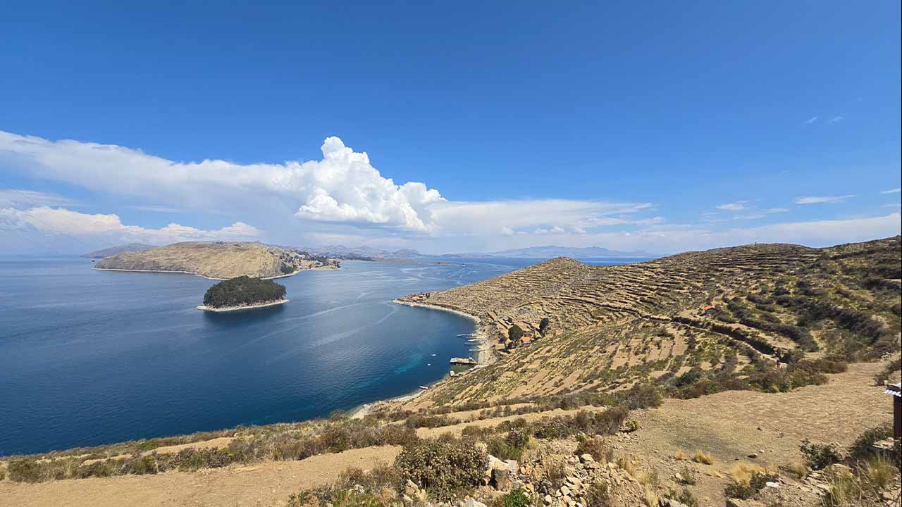 View of Isla del Sol with terraced hills and surrounding blue waters of Lake Titicaca