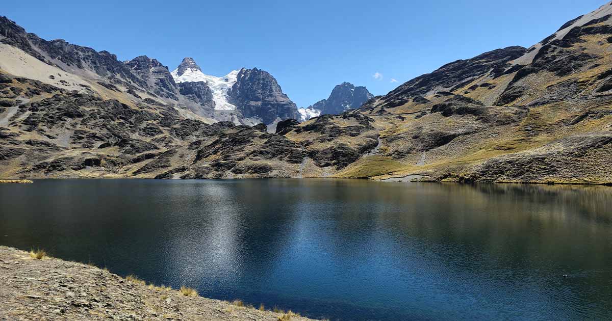 Lake surrounded by rugged mountains during the ascent to Pico Austria in Bolivia