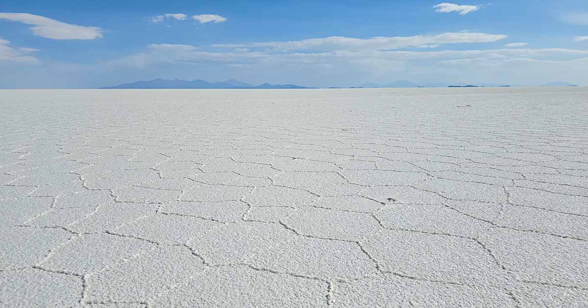 The endless salt flats of Salar de Uyuni under a clear blue sky.