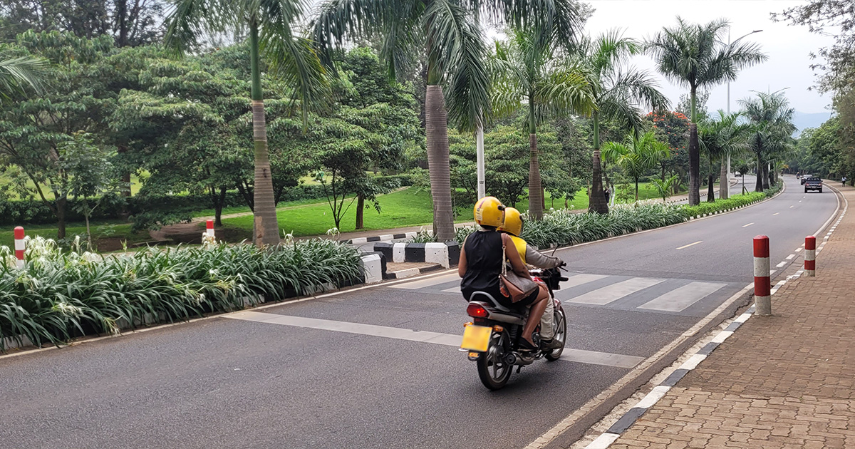 A motorcycle on a tree-lined street in Kigali, Rwanda