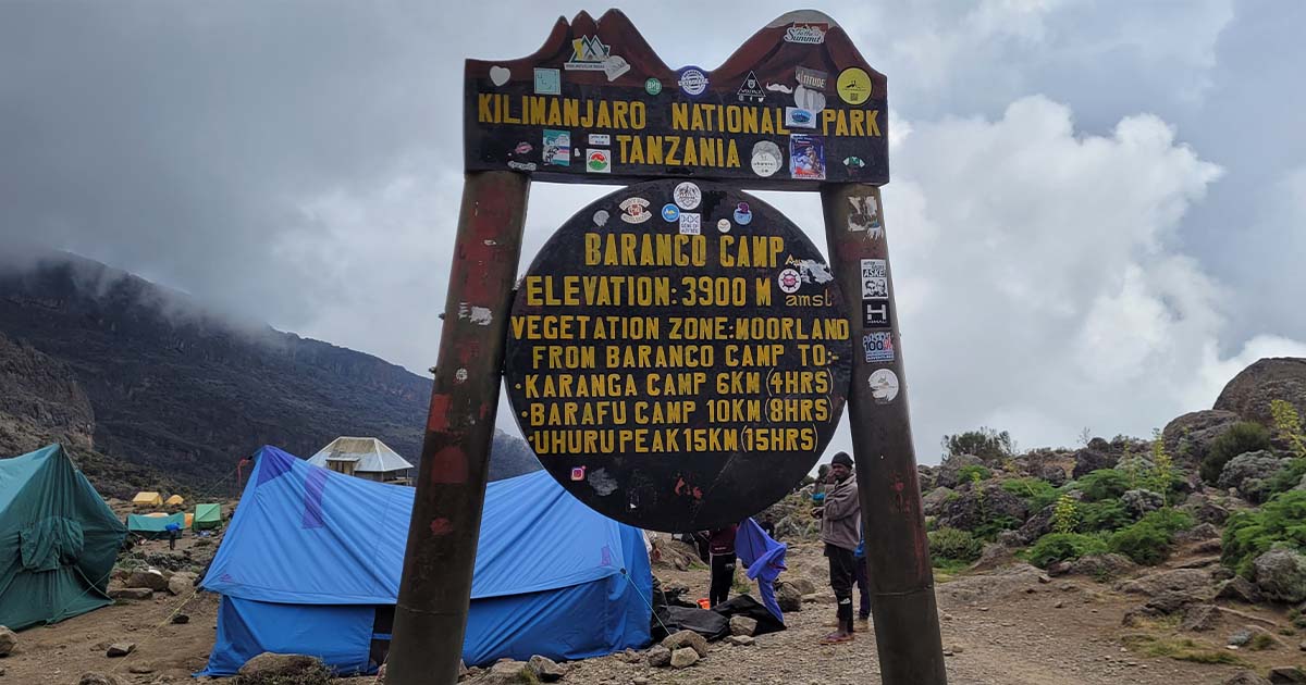 A signpost at Barranco Camp detailing elevation and distance to Kilimanjaro's summit and other camps